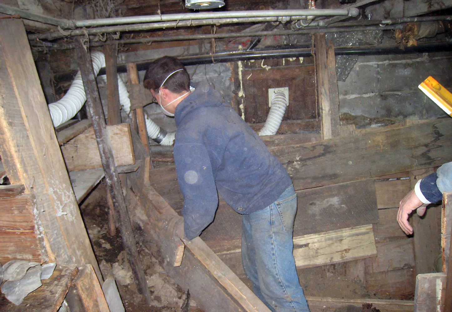 Kyle ripping out boards in the basement to make digging easier. Jim's quart J. Tune was found behind the small wall to the left.